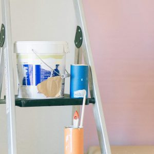 A ladder with painting tools and materials used for home renovation and interior design.